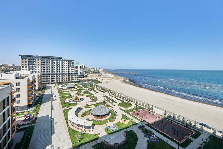 Dənizin düz kənarında tikilmiş binalardakı mənzillər satılır